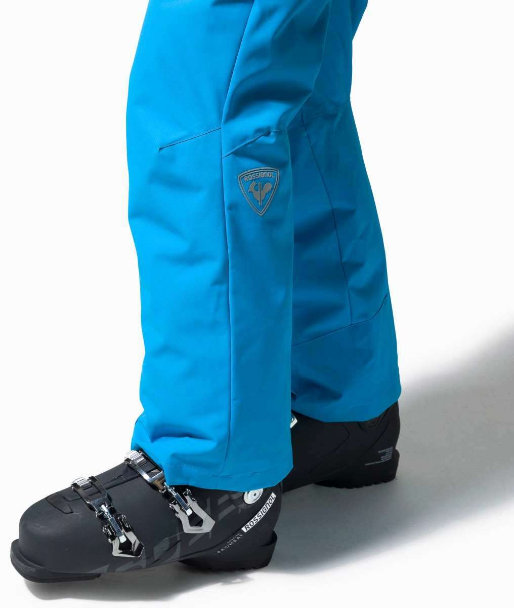 Rossignol Rapide Insulated Pant 2022-2023 - A pair of bright blue ski pants with a logo on the left thigh and two zippered pockets on the side.