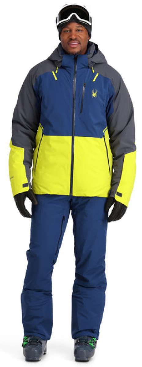 Spyder Vanqysh Insulated Jacket 2023 - A navy blue and yellow ski jacket with a zippered chest pocket, worn by a model on a plain background.