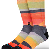Stance Abstruse Crew Socks 2023 - A pair of crew socks in a vibrant, abstract pattern featuring shades of orange, yellow, green, and gray stripes.