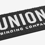 Union Surf Stomp Pad - Black surfboard pad with white logo on top.