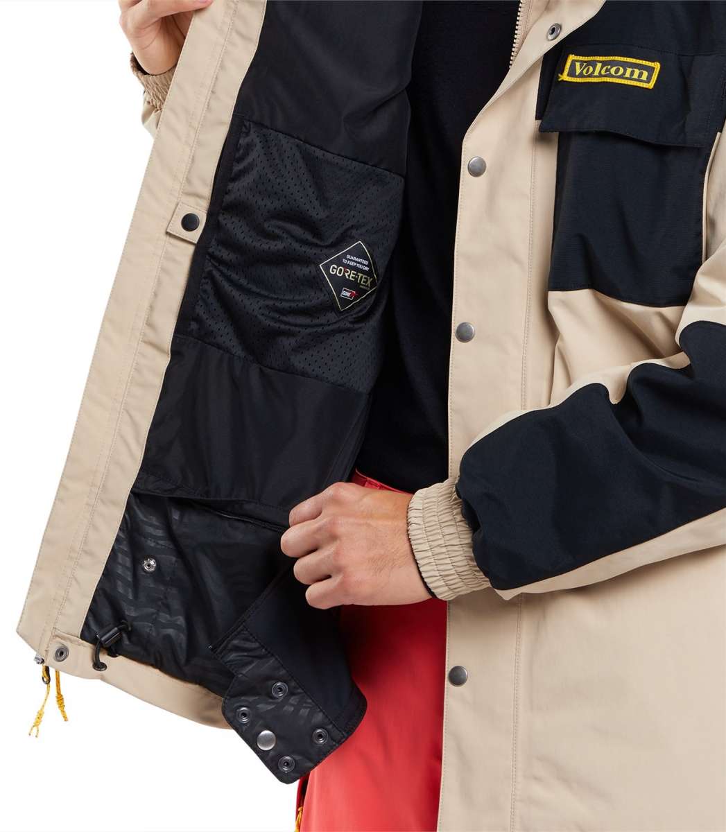 Volcom Longo GORE-TEX Shell Jacket 2024 - A black and tan jacket with a yellow logo on the chest, featuring a zipper closure.