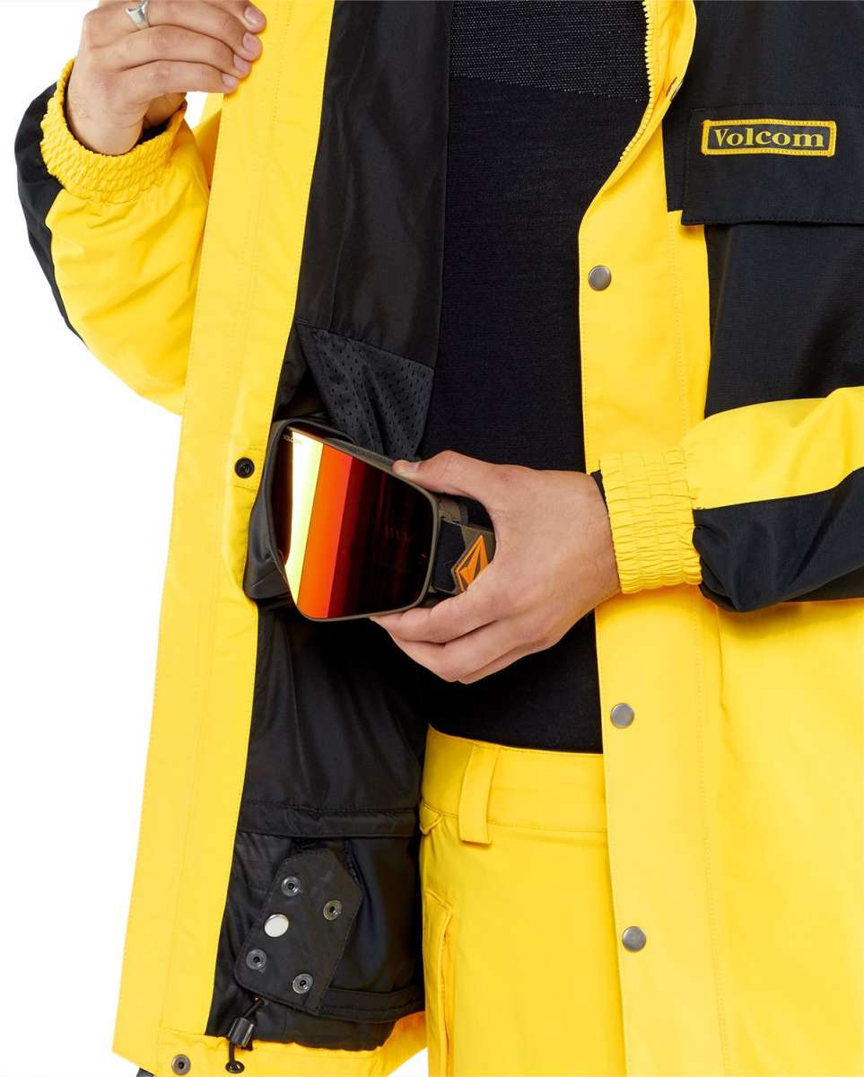 Volcom Longo GORE-TEX Shell Jacket 2024 - A black and yellow jacket with a zippered chest pocket, featuring a Volcom logo patch on the left side of the chest.