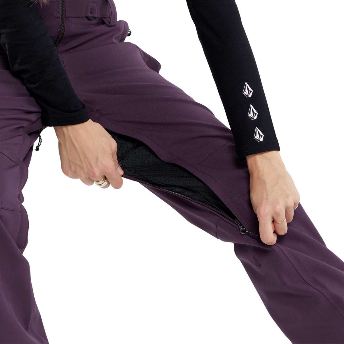Volcom Women's Swift Bib Overall Pant - A pair of purple snowboard pants with a black zipper and white logo on the left leg.