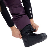 Volcom Women's Swift Bib Overall Pant - A pair of purple snowboard pants with a white logo on the left thigh and black accents around the waistband.