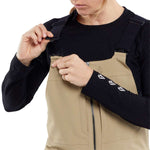 Volcom Women's Swift Bib Overall Pant 2024 - A pair of tan bib overalls with a zippered front and adjustable straps.