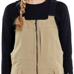 Volcom Women's Swift Bib Overall Pant 2024 - A pair of khaki-colored bib overalls with a zippered front and adjustable straps.