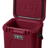 Yeti Roadie 24 Hard Cooler - A red cooler with a handle on top and a latch to secure the lid.