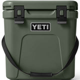 Yeti Roadie 24 Hard Cooler - A dark green cooler with a handle on top and two latches on either side of it.