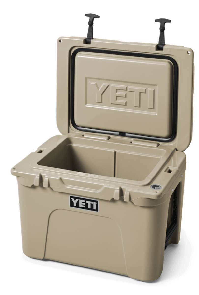 Yeti Tundra 35 Hard Cooler - A tan-colored cooler with a rectangular shape and a handle on top, featuring the word "YETI" embossed in silver letters on its front side.