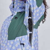 Airblaster Women's Freedom Insulated Suit 2024 - A light blue snowsuit with a repeating pattern of white daisies and yellow centers, featuring black zippers and a black logo on the chest.