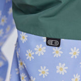 Airblaster Women's Freedom Insulated Suit 2024 - A light blue snowsuit with a repeating pattern of white flowers and yellow centers, featuring a black tag with "EO" in white text on the waistband.