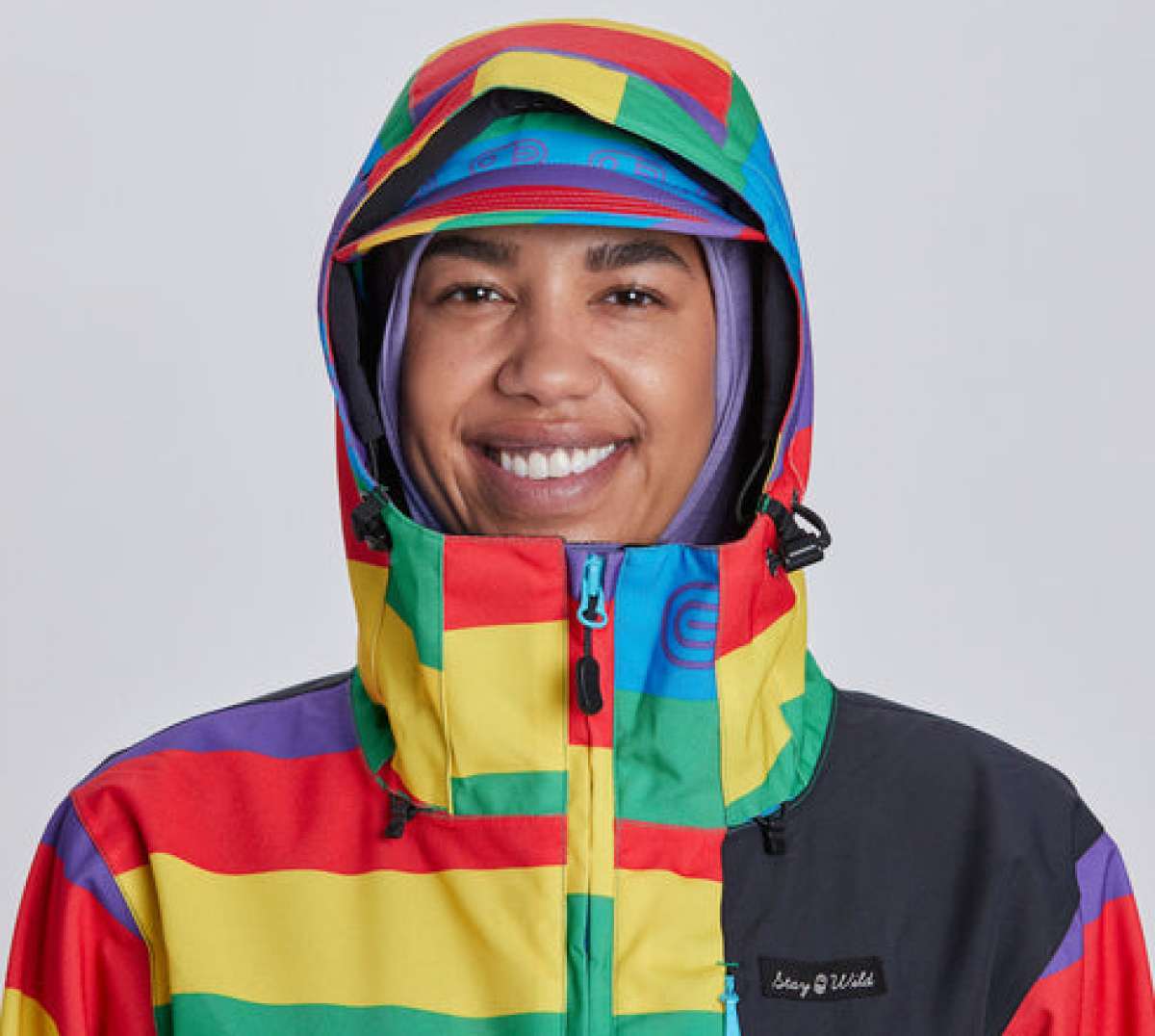 Airblaster Women's Freedom Stretch Suit 2024 - A woman wearing a black, purple, and pink suit with a geometric pattern on the arms and legs.