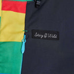 Airblaster Women's Freedom Stretch Suit 2024 - A black, red, yellow, and green full-body snowsuit with a zipper down the front.