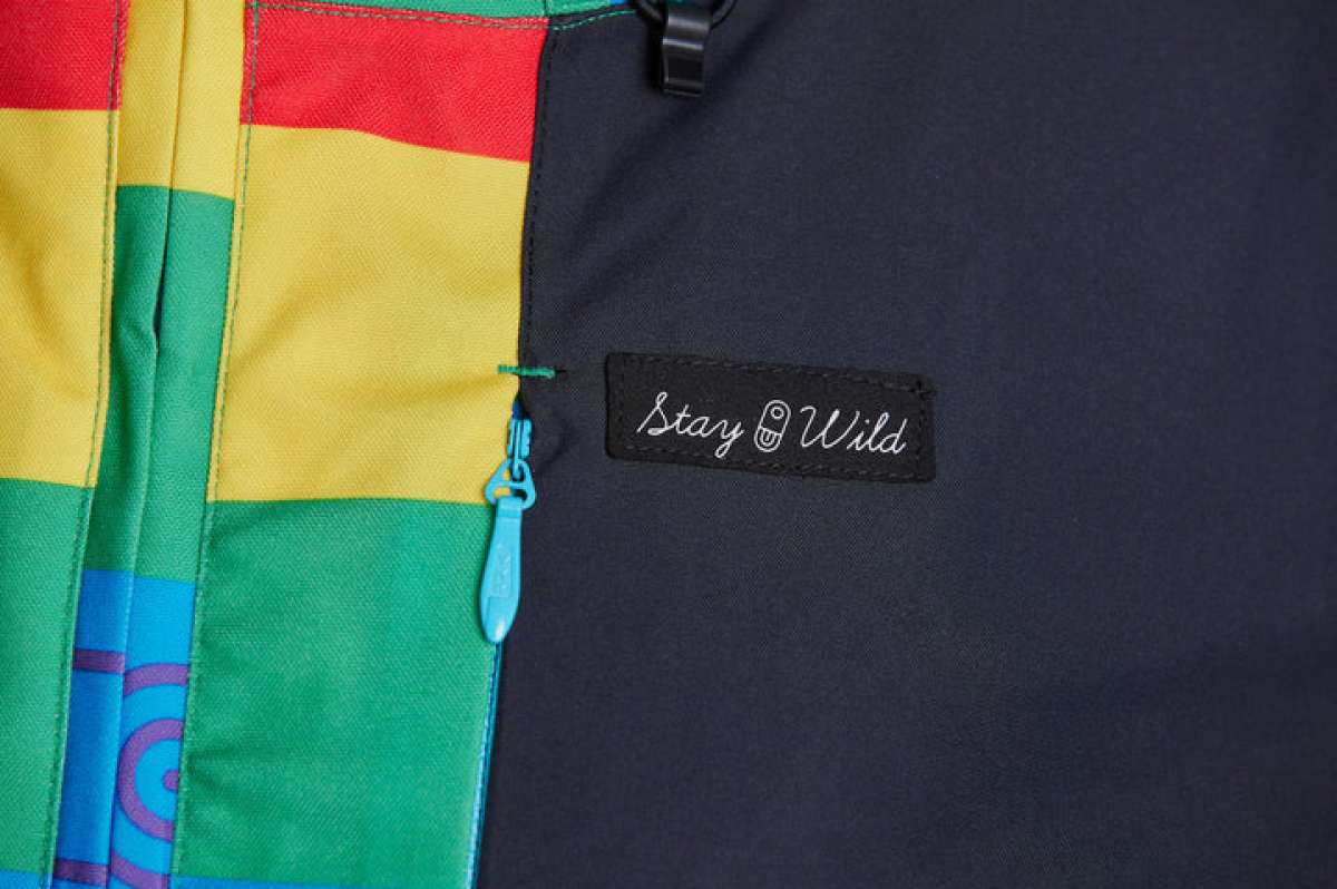 Airblaster Women's Freedom Stretch Suit 2024 - A black, red, yellow, and green full-body snowsuit with a zipper down the front.