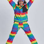 Airblaster Women's Freedom Stretch Suit 2024 - A woman wearing a rainbow-striped, multicolored snowsuit with black accents and a matching hat.