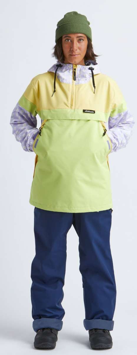 Airblaster Women's Trenchover Insulated Jacket 2022 - A black and white jacket with a hood, worn by a model posing in front of a plain background.