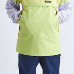 Airblaster Women's Trenchover Insulated Jacket 2022 - A black and white jacket with a hood, worn by a model posing in front of a plain background.