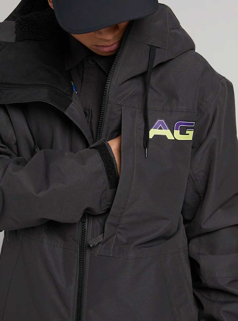 Analog Greed Jacket - A black jacket with a blue logo on the left chest and a white tag on the right sleeve.