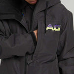 Analog Greed Jacket - A black jacket with a blue logo on the left chest and a white tag on the right sleeve.