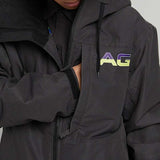 Analog Greed Jacket - A black jacket with a blue logo on the left chest and a white tag on the right sleeve.