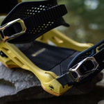 Arbor Cypress Snowboard Bindings 2024 - A pair of black bindings with silver buckles and straps, featuring a textured pattern on the baseplate.