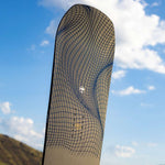 Arbor Draft Camber Snowboard 2024 - A black snowboard with a grid pattern on top of a brown background.