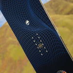 Arbor Draft Camber Snowboard 2024 - A black snowboard with a blue geometric pattern and white logo on top.