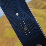 Arbor Draft Camber Snowboard 2024 - A black snowboard with a blue geometric pattern and white logo on top.