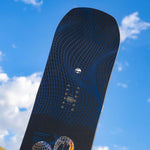 Arbor Draft Camber Snowboard 2024 - A black snowboard with a blue geometric pattern and white logo on top.