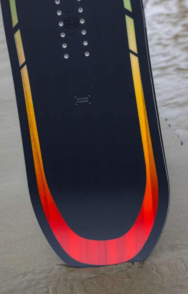Arbor Formula Rocker Snowboard 2024 - A black snowboard with a yellow and red gradient stripe along its bottom edge.