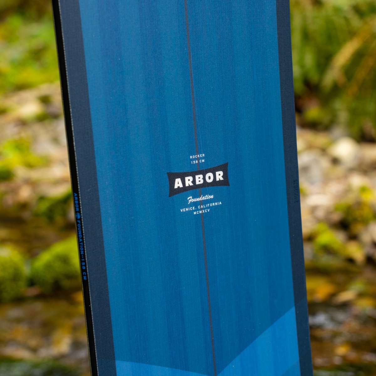 Arbor Foundation Rocker Snowboard 2024 - A blue snowboard with a black logo that says "ARBOR" in white letters.