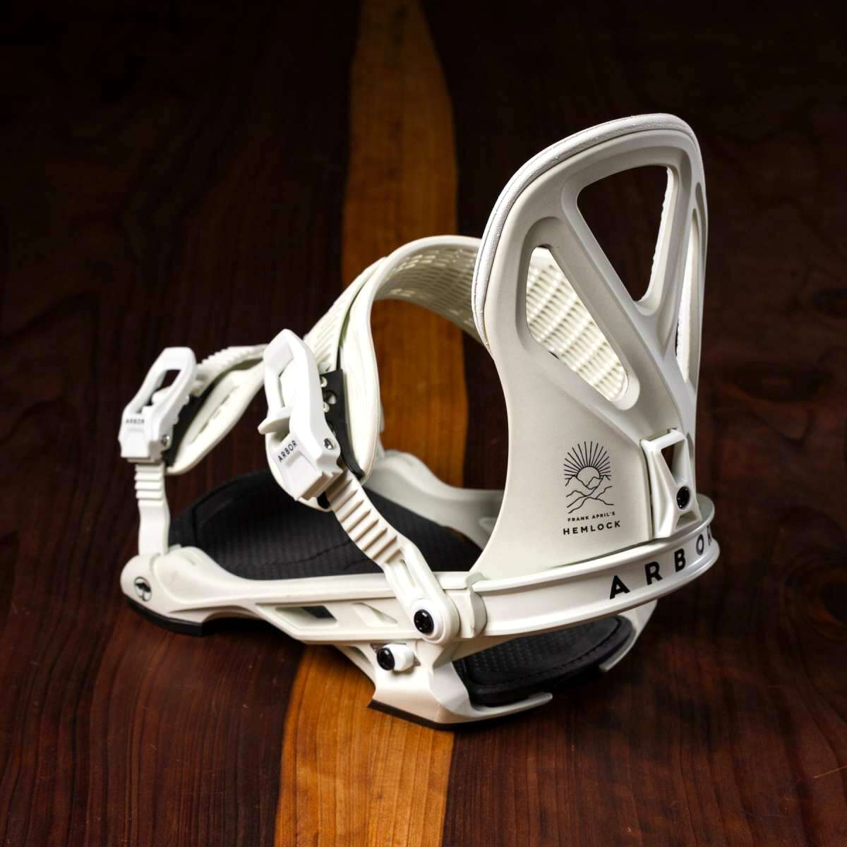 Arbor Hemlock Snowboard Bindings 2023 - White bindings with black straps and buckles, featuring a sunburst logo on the strap.