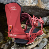 Arbor Women's Sequoia Snowboard Bindings 2024 - A pair of red snowboard bindings with white lettering, featuring a sunburst logo above the word "Sequoia".
