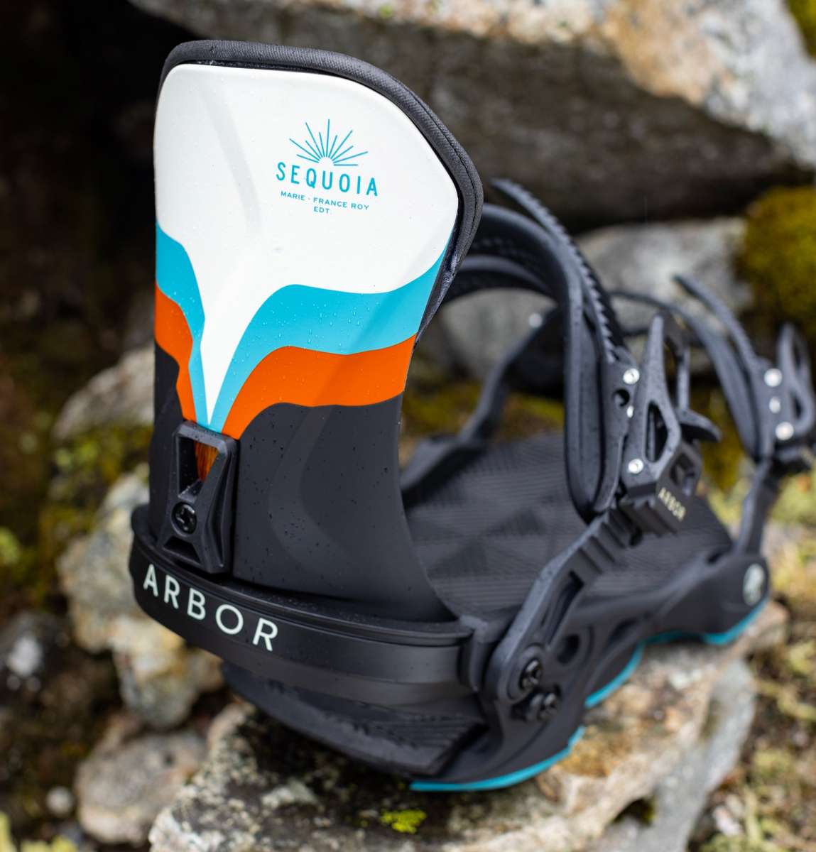 Arbor Women's Sequoia Snowboard Bindings 2024 - A white, blue and orange snowboard binding with a black strap that says "ARBOR" in white letters.