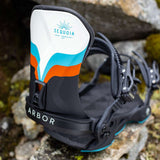 Arbor Women's Sequoia Snowboard Bindings 2024 - A white, blue and orange snowboard binding with a black strap that says "ARBOR" in white letters.