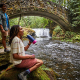 Hydro Flask Small Flex Bottle - Blue water bottle with a pink lid, held by a person wearing a white shirt and khaki shorts.