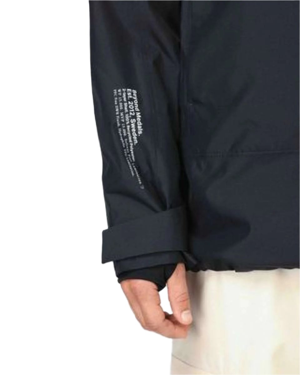 Beyond Medals Anorak 2L Shell Jacket 2024 - A black jacket with a white logo on the left chest and white text on the right sleeve.