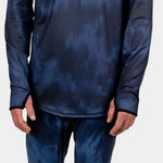 BlackStrap Summit Bottom Baselayer - A man wearing a black baselayer with a subtle pattern of lighter gray lines, paired with a white beanie and standing against a light gray background.