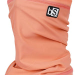 BlackStrap The Tube Solid Dual Layer 2024 - A peach-colored neck gaiter with a black logo patch on the upper right side.