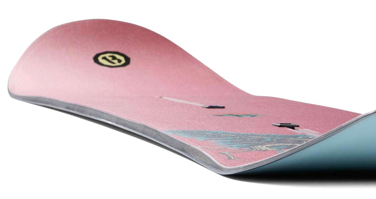 Burton 1995 Kelly Air 2024 - A pink snowboard with a black logo featuring a white "B" and a yellow circle around it.