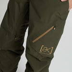 Burton AK GORE-TEX Cyclic Pant 2023 - Dark green pants with a zippered pocket on the thigh and a small star-shaped zipper pull.