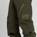 Burton AK GORE-TEX Cyclic Pant 2023 - Dark green pants with a zippered pocket on the right thigh and a small Burton logo in gold on the left leg.