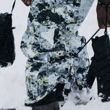 Burton AK GORE-TEX Cyclic Pant 2023 - Black snow pants with yellow and white abstract pattern, featuring black zippers on side pockets.