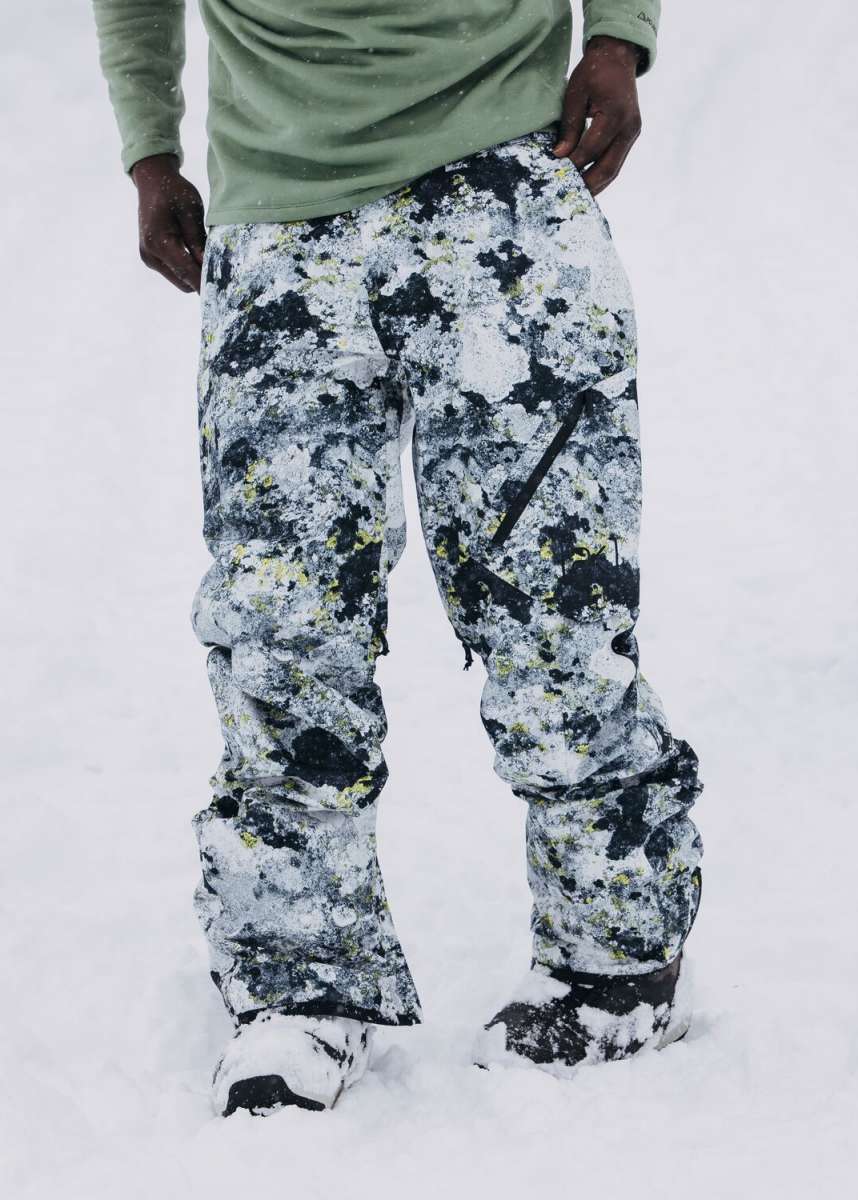 Burton AK GORE-TEX Cyclic Pant 2023 - Black snow pants with a subtle yellow pattern and black accents, featuring a zippered pocket on the right thigh.