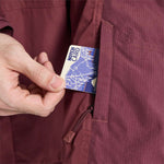 Burton Frostner 2L Jacket 2024 - A blue jacket with a white snowflake pattern on the sleeve and chest, worn by a model in front of a snowy background.