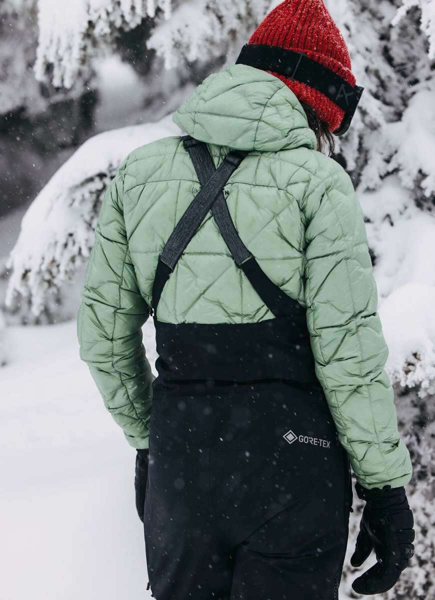 Burton Women's AK Gore-Tex Kimmy Bib Pant 2023 - A black bib pant with a white logo on the left leg and adjustable straps over the shoulders.
