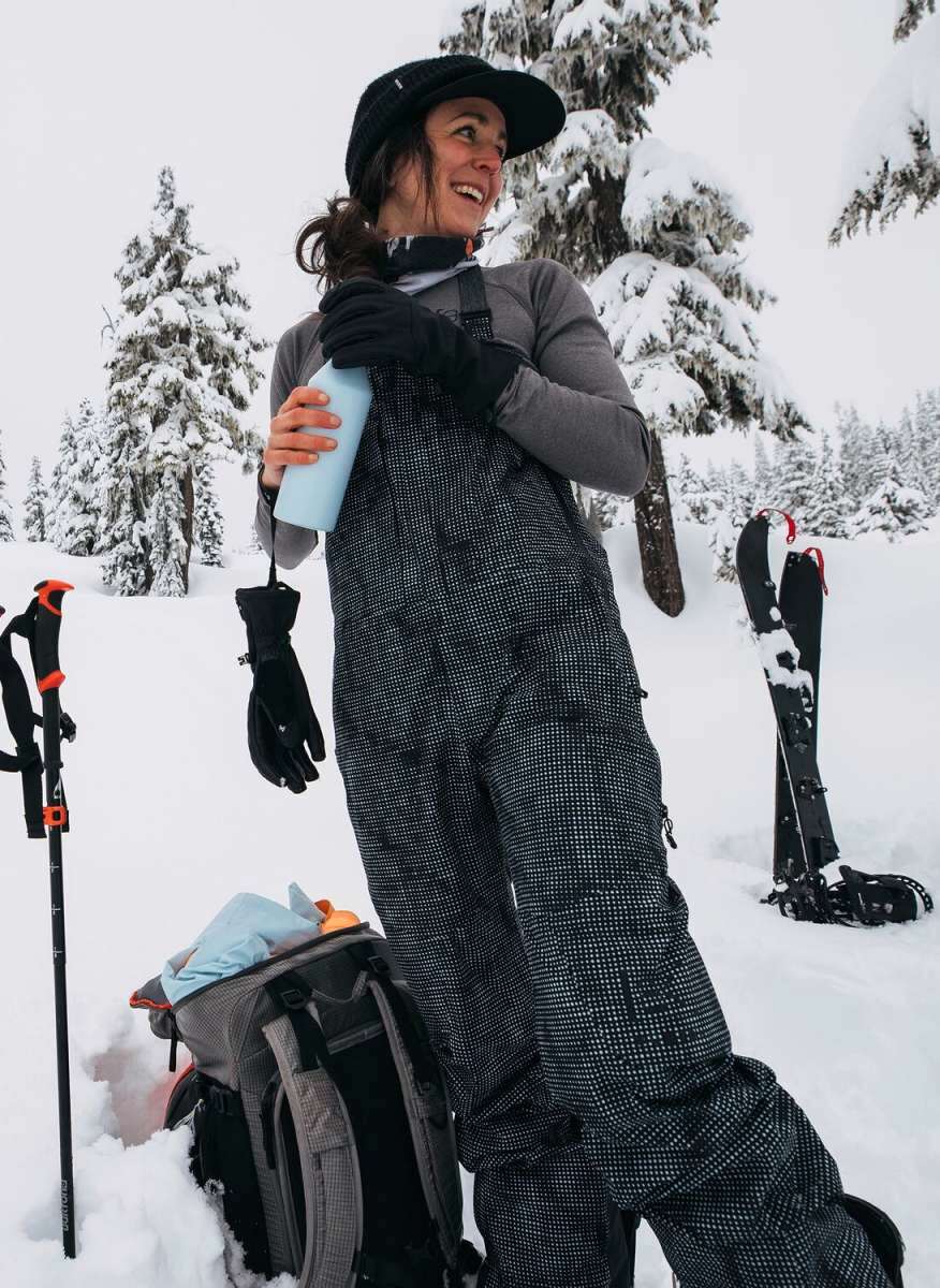 Burton Women's AK Gore-Tex Kimmy Bib Pant 2023 - Black snow pants with white dots and a black strap on the side.