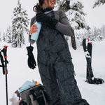 Burton Women's AK Gore-Tex Kimmy Bib Pant 2023 - Black snow pants with white dots and a black strap on the side.
