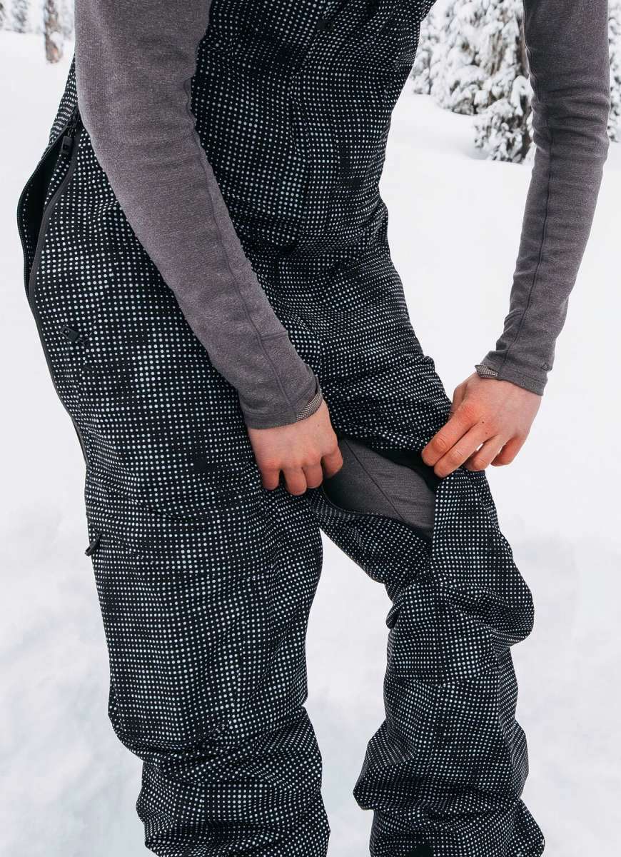 Burton Women's AK Gore-Tex Kimmy Bib Pant 2023 - Black bib pant with white dots and a zippered pocket on the thigh.