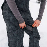 Burton Women's AK Gore-Tex Kimmy Bib Pant 2023 - Black bib pant with white dots and a zippered pocket on the thigh.